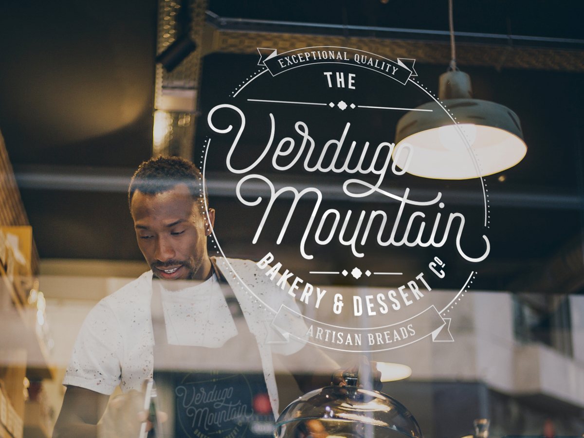 A team member working behind the counter at The Verdugo Mountain Bakery storefront window